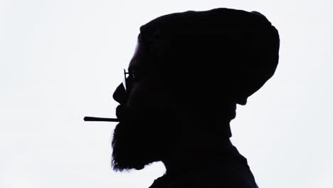 Silhouette-of-bearded-man-lighting-marijuana-joint,-smoking-and-exhaling,-white-background,-cannabis