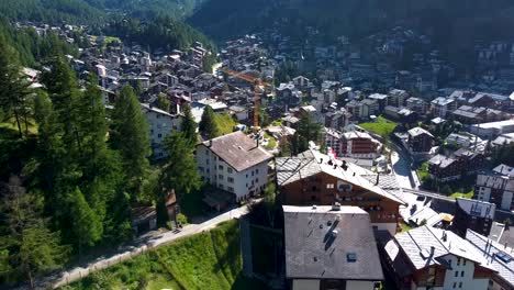 Township-buildings-of-Zermatt-on-sunny-warm-day,-aerial-drone-view