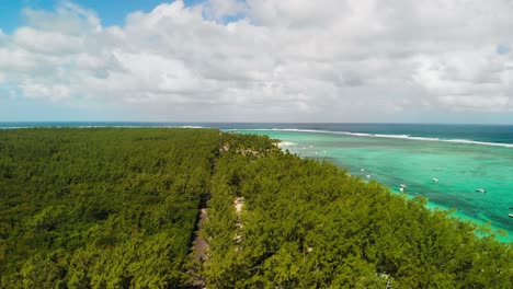 Grüne-Bäume-Der-Insel-Mauritius-Und-Auf-Dem-Wasser-Geparkte-Boote-Am-Strand-Von-Le-Morne-Unter-Weißen-Wolken