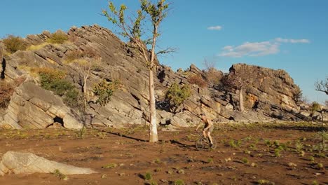Ein-Junger-Mann-Startet-Mit-Seinem-Fahrrad-Von-Einem-Felsen-Im-Australischen-Outback
