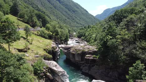 Vuelo-Aéreo-Lento-Del-Río-Natural-Entre-Rocas-Y-Montañas-Verdes-En-Suiza