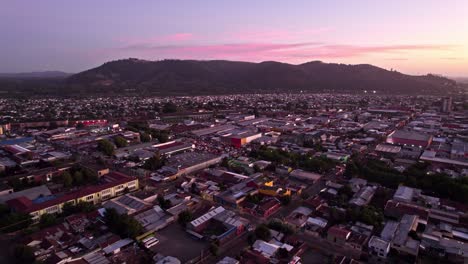 Luftdrohne-über-Temuco,-Chile,-Sonnenaufgangszeit,-Hügel,-Häuser-Und-Stadtstraßen,-Rosafarbener-Skyline-Horizont,-Provinz-Cautin
