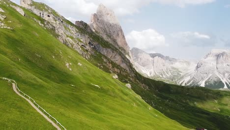 Grüner-Wiesenhang-Und-Weg,-Der-Zu-Den-Dolomiten-Italiens-Führt,-Luftaufnahme