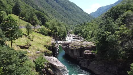 Luftaufnahme-Rückwärts-über-Einem-Wunderschönen-Fluss-In-Der-Schweiz,-Umgeben-Von-Grünen-Bergen-Im-Sommer