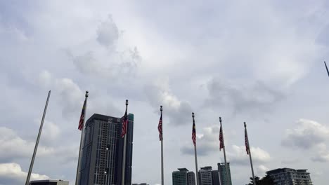 A-low-angle-shot-of-the-flags-hosted-by-the-KL-towers