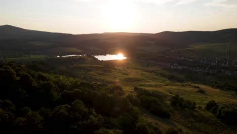 Sonnenlicht-Wird-Vom-Teich-Inmitten-Sanfter-Hügel,-Varbo,-Ungarn,-Reflektiert