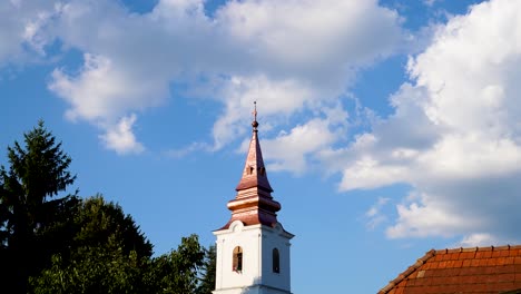 Clouds-moving-over-small-church-steeple,-Varbo,-Hungary