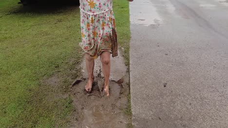 Unrecognizable-Young-Little-Girl-With-Dress-Jumping-in-Mud-Puddle,-Slow-Motion