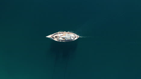 AERIAL---Sailboat-on-Correntoso-Lake,-Neuquen,-Argentina,-top-down-tracking-shot