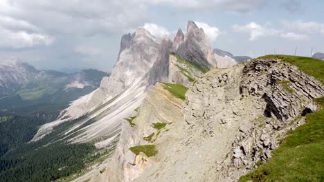 Steep-slopes-of-Dolomites-in-Italy-with-person-trekking-on-top,-aerial-view