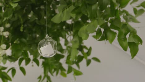 Led-candle-hanging-from-a-leaf.-Slow-motion