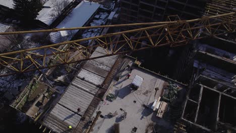 Overview-of-crane-in-a-construction-site-with-workers-walking