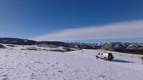 Drohnen-Luftaufnahme-Eines-Lieferwagens-In-Den-Colorado-Mountains,-Der-In-Die-Schneeszene-Ein--Und-Aussteigt