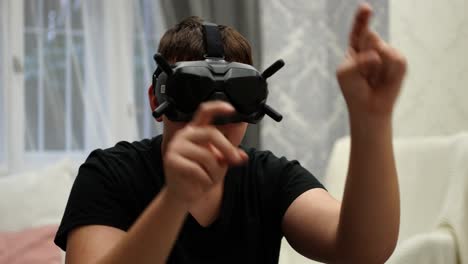 Junger-Mann-Mit-Brille,-VR-Brille-In-Der-Virtuellen-Realität,-Der-Mit-Den-Händen-Auf-Einen-Unsichtbaren-Bildschirm-Tippt