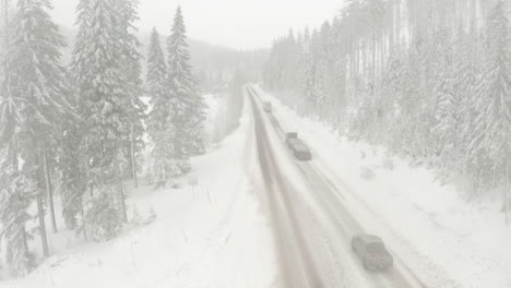 Absteigende-Luftaufnahme-Von-Lastwagen,-Die-Durch-Verschneite-Bedingungen-Fahren