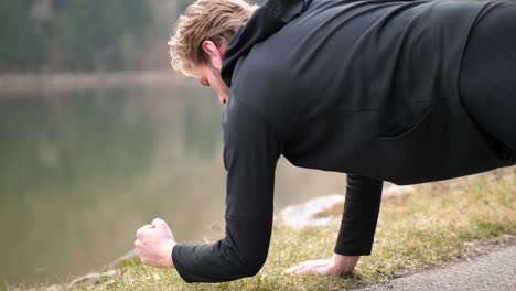 an-athletic-young-man-with-blond-hair-doing-a-mixture-of-planks-and-pushups-is-seen-here