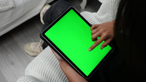 Female-Hand-and-Finger-on-Green-Screen-Tablet-Swiping-Up-Multiple-Pages,-Close-Up-Overhead-View
