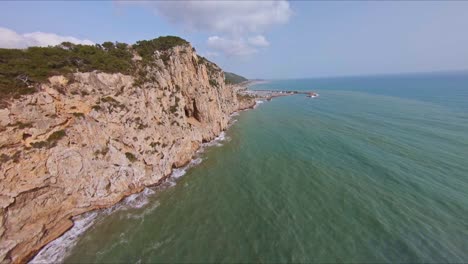 Scenic-aerial-view-flying-beside-oceanside-cliffs-along-the-Mediterranean-coast-in-Garraf,-Spain