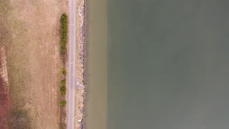 Drone-flies-in-bird's-eye-view-along-the-brown---green-banks-of-the-Danube