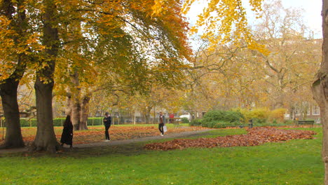 Gente-Caminando-Durante-La-Temporada-De-Otoño-En-Los-Jardines-De-Brunswick-Square-En-Londres,-Inglaterra