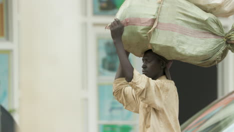 Zeitlupenschwenkaufnahme-Einer-Person,-Die-In-Kigali,-Ruanda,-Einen-Leinensack-Auf-Dem-Kopf-Trägt