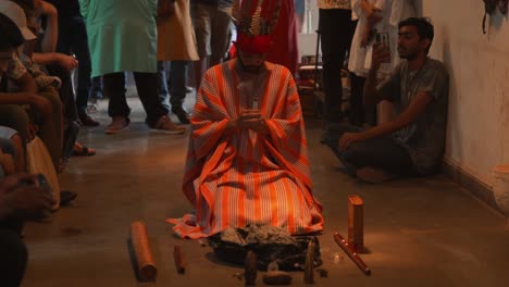 Heiliger-Mann,-Der-Ein-Hinduistisches-Ritual-Durchführt,-Während-Er-Eine-Zeremonielle-Kleidung-Trägt