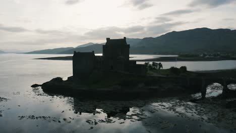 Castle-silhouette-in-Scotland's-countryside-surrounded-by-water