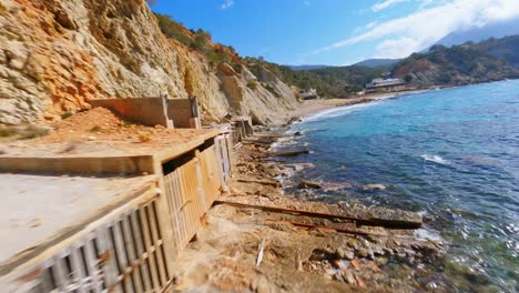 FPV-drone-flying-along-the-Spanish-coast-and-through-the-balcony-of-a-boathouse