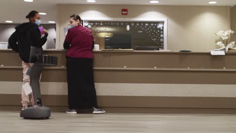 Zwei-Krankenschwestern-Unterhalten-Sich-Und-Beobachten-Einen-Telemedizin-Roboter,-Der-Sich-Durch-Die-Lobby-Des-Krankenhauses-Bewegt