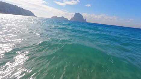 FPV-aerial-view-flying-across-the-water-toward-Es-Vedra-and-Vedranell-islands-off-the-coast-of-Ibiza