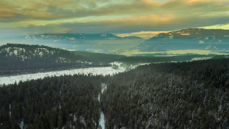 Atemberaubende-Luftaufnahmen-Einer-Winterlandschaft-Mit-Stromleitungen,-Die-Durch-Schneebedeckte-Berge-Verlaufen