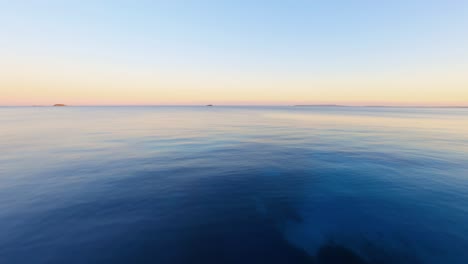 FPV-Luftaufnahmen-Fliegen-Schnell-über-Den-Ozean-Und-Zeigen-Bei-Sonnenuntergang-Resorts-Entlang-Der-Malerischen-Küste-Von-Ibiza