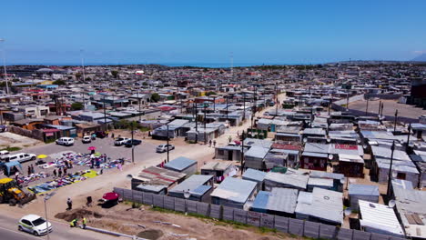 Aerial-riser-over-township-with-market-and-corrugated-iron-shacks