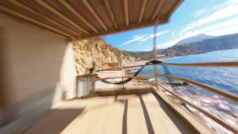 Epic-FPV-aerial-flying-through-a-boathouse-patio-along-the-scenic-coast-of-Spain