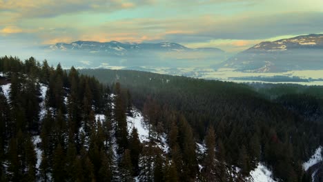 Majestic-Aerial-View-of-Wintery-Mountains-and-Forests-in-Enderby,-BC-at-Sunset