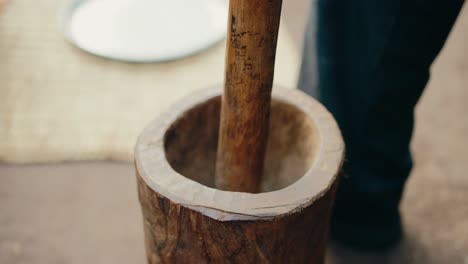 Close-up-view-of-wooden-mortar-and-pestle-used-to-manually-grind-coffee-beans