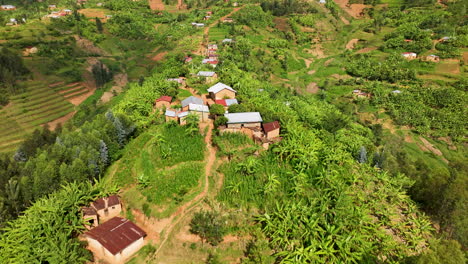 Drone-flies-over-rural-homes-on-a-mountain-side-ridge-in-Rwanda