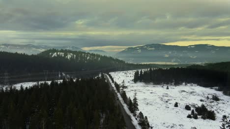Breathtaking-Winter-Wonderland:-Aerial-Footage-of-Power-Lines-Snaking-Through-Snowy-Tree-Mountain-Landscape
