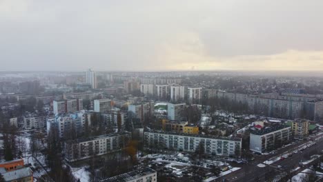 Purvciems-soviet-style-apartment-blocks-during-winter-snowfall-in-Latvia,-aerial