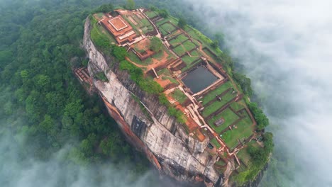 Aerial-video-over-Lion's-Rock-in-Sigiriya-,-historical-mountain-with-historical-constructions-above-the-clouds