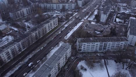 Gray-overcast-day-with-snowfall-over-apartment-building-district-in-Russia,-drone-view