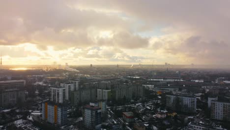 Cinematic-4K-aerial-dolly-in-view-view-at-sunset-of-Riga-city-while-it-snows