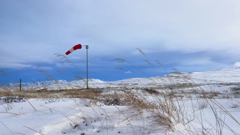 Windsack-Weht-Im-Arktischen-Winterwind-Auf-Dem-Flugplatz-Blönduos-In-Der-Nordisländischen-Landschaft