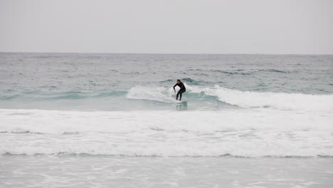 Weißer-Surfer-Im-Schwarzen-Neoprenanzug-Fängt-Welle-In-Monterey-Bay,-Kalifornien