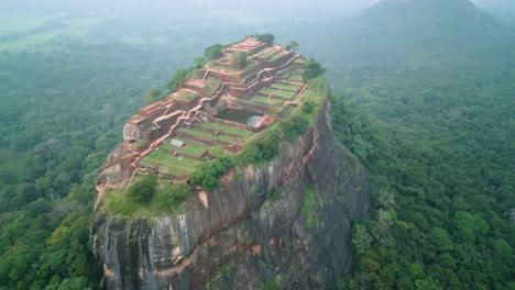 Lion's-Rock-in-Sigiriya-,-mountain-with-historical-buildings-among-great-vegetation,-sunset-on-a-cloudy-day