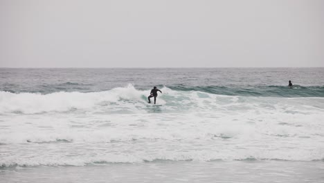 Surfista-Blanco-En-Traje-De-Neopreno-Negro-Surfeando-Una-Pequeña-Ola-En-La-Bahía-De-Monterey-California