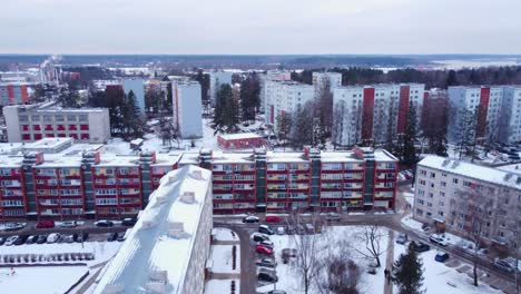 Soviet-time-buildings-covered-in-white-snow,-aerial-drone-established,-day