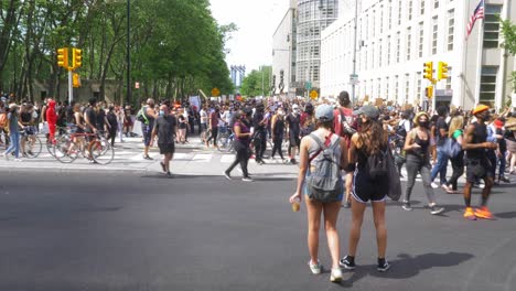 Zwei-Mädchen-Beobachten-Eine-Große-Menge-Demonstranten,-Die-Vorbeiziehen