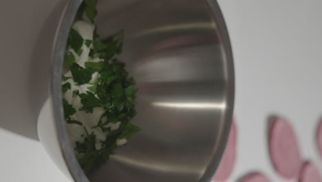 Sprinkle-fresh-parsley-into-mixing-bowl-with-yogurt