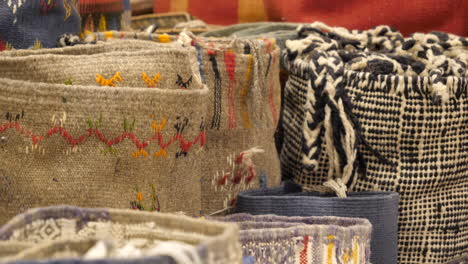 Different-kinds-of-woven-Persian-carpets-for-sale-on-Marrakesh-bazaar-stall,-Close-up